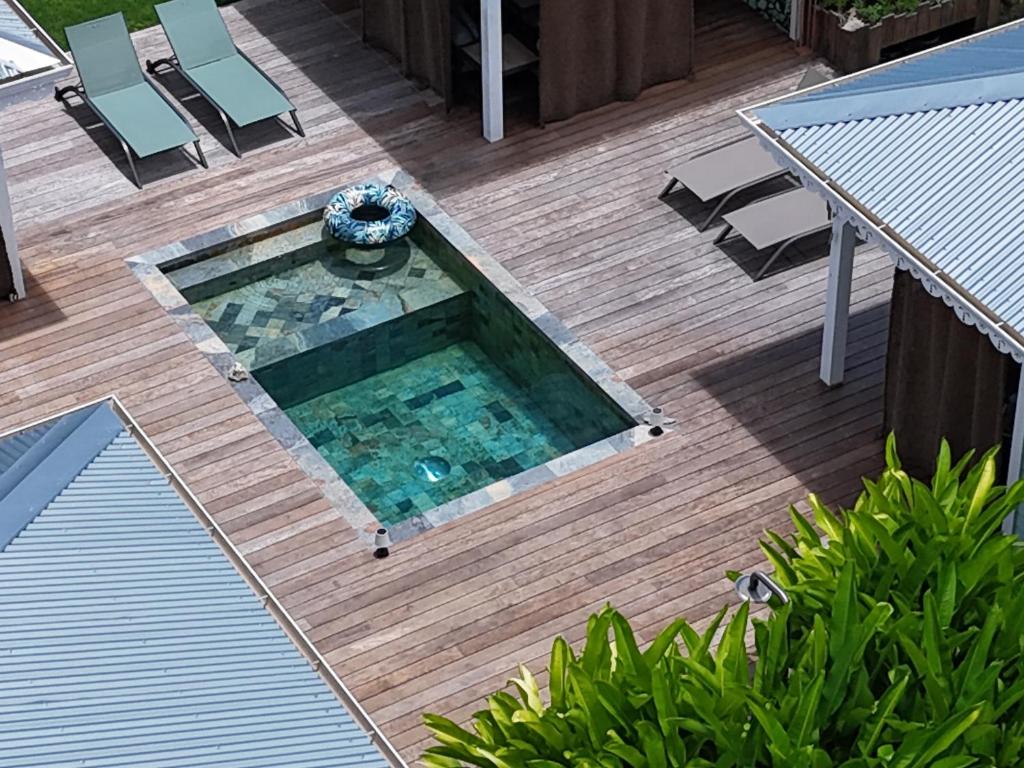 an overhead view of a swimming pool on a wooden deck at Les Kaz de Sainte Anne in Sainte-Anne