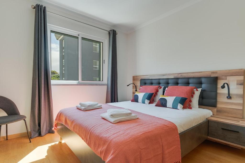 a bedroom with a large bed and a window at Atlantic Dutchman Heated Pool & Parking in Caniço