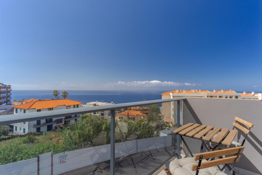 a balcony with a table and chairs and the ocean at Jardins Do Oceano Ii Modern Stay Near Beach in Caniço