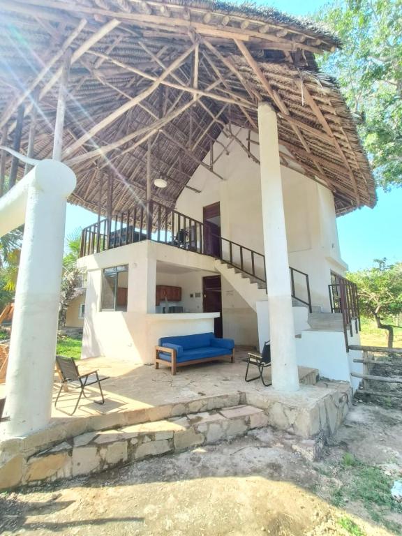 a house with a blue couch under a roof at Seasoul Sanctuary in Shimoni