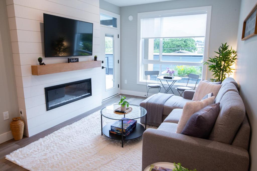 a living room with two couches and a fireplace at New 1 Bed Condo with Mtn Views in Harrison Hot Springs