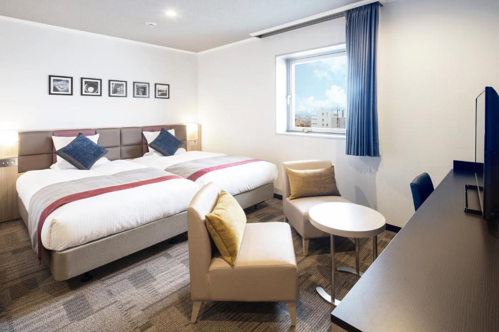 a hotel room with a bed and a chair and a table at HOTEL MYSTAYS Tachikawa in Tachikawa