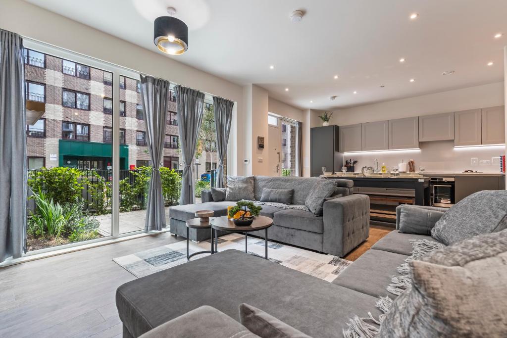 a living room with couches and a kitchen at 3 Bed Duplex, Pool Table, 4 Stops to Wembley in Hatch End