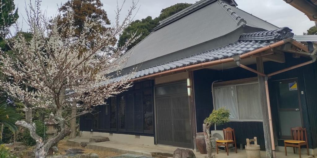 a blue house with a gray roof and a tree at 神乃宿 in Shimonoseki