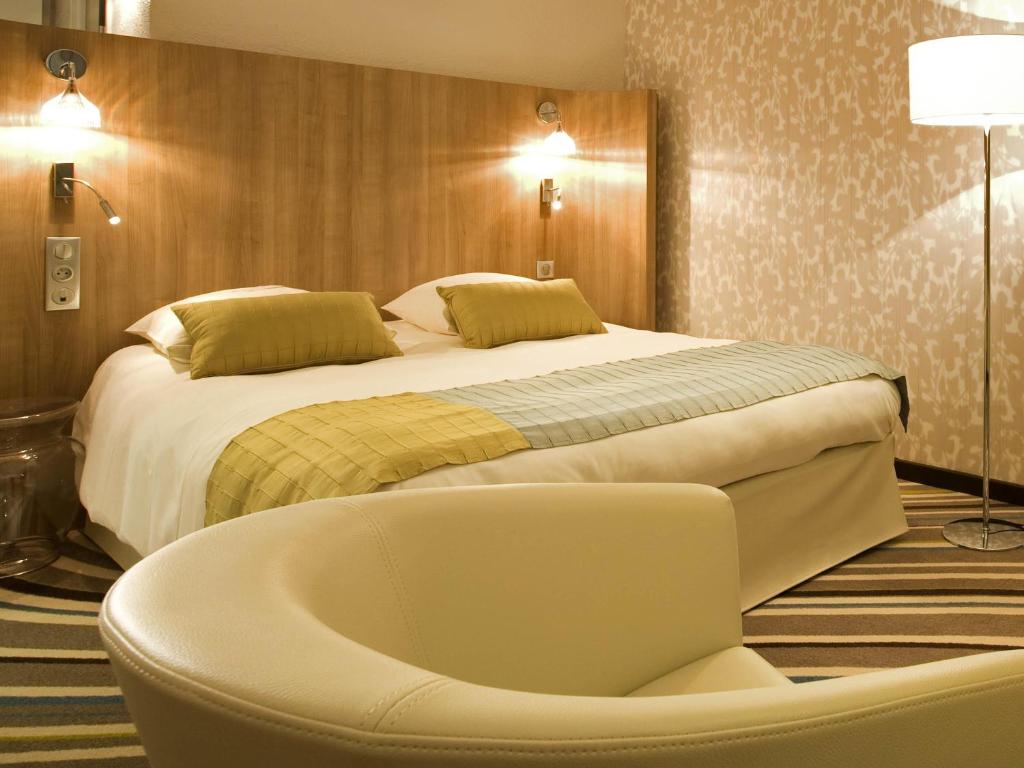ein Schlafzimmer mit Bett und Badewanne in der Unterkunft Mercure Angers Centre de Congrès in Angers