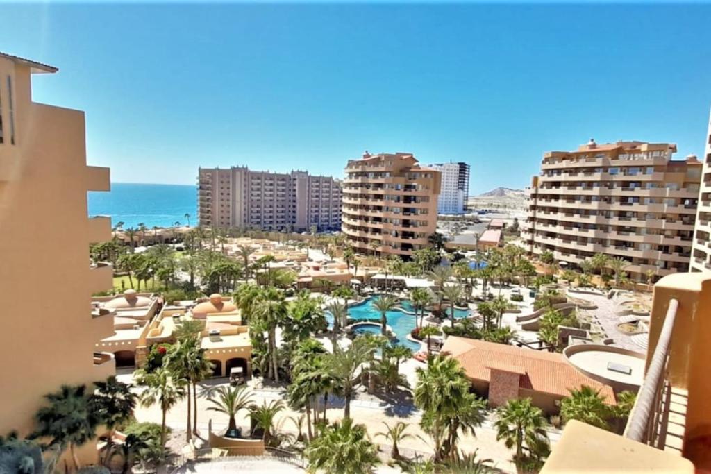 a view of a resort with palm trees and the ocean at Bella Sirena 601-B -Stylish Condo in Oceanfront Resort in Puerto Peñasco