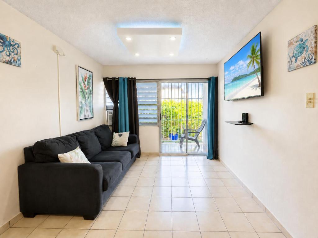 a living room with a black couch and a window at 30 seconds beach aparment in Aguacate