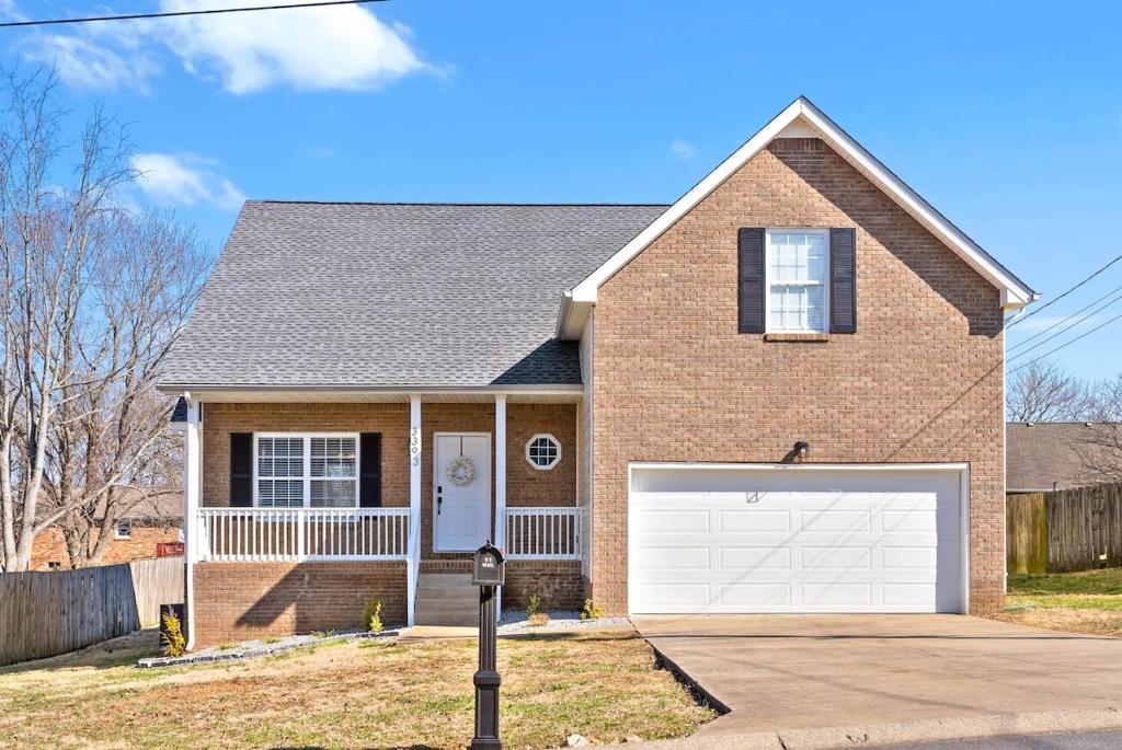 a brick house with a white garage door at Hollywood Hideaway in Clarksville
