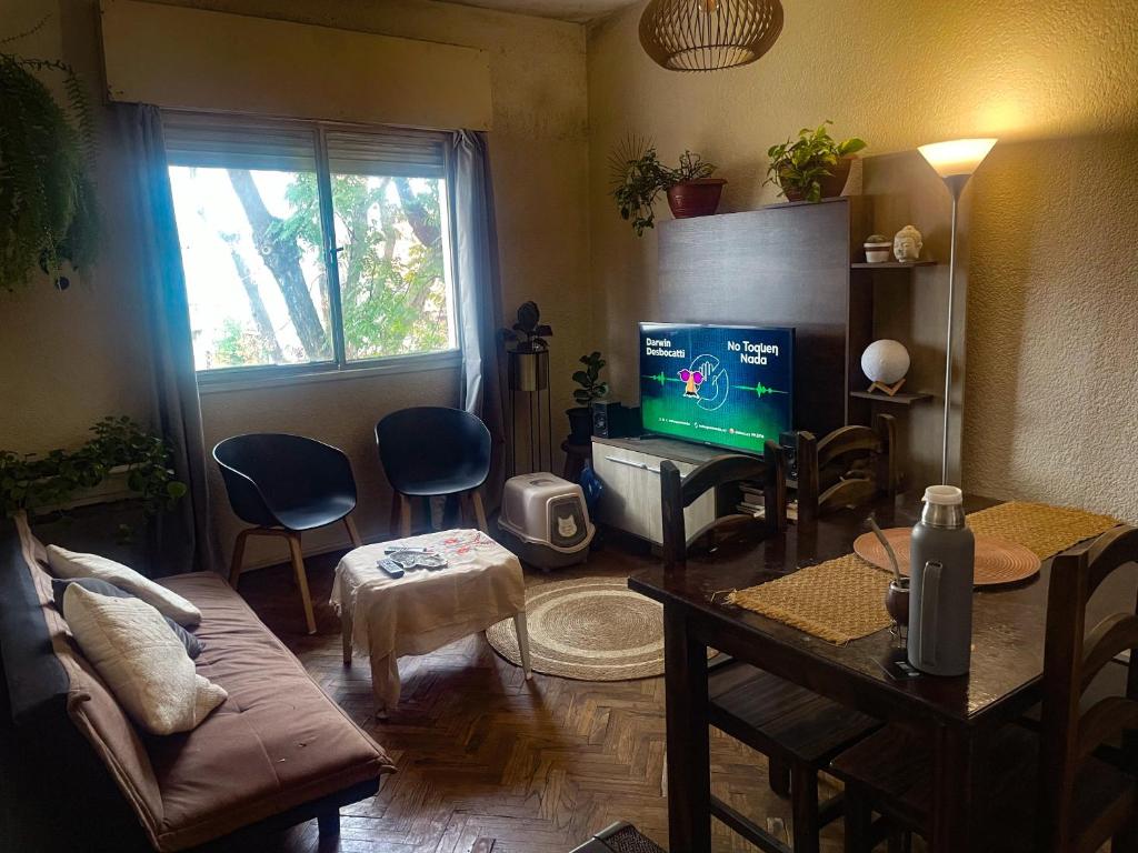 a living room with a couch and a television at Cómodo, bien ubicado y con host multilingüe in Montevideo