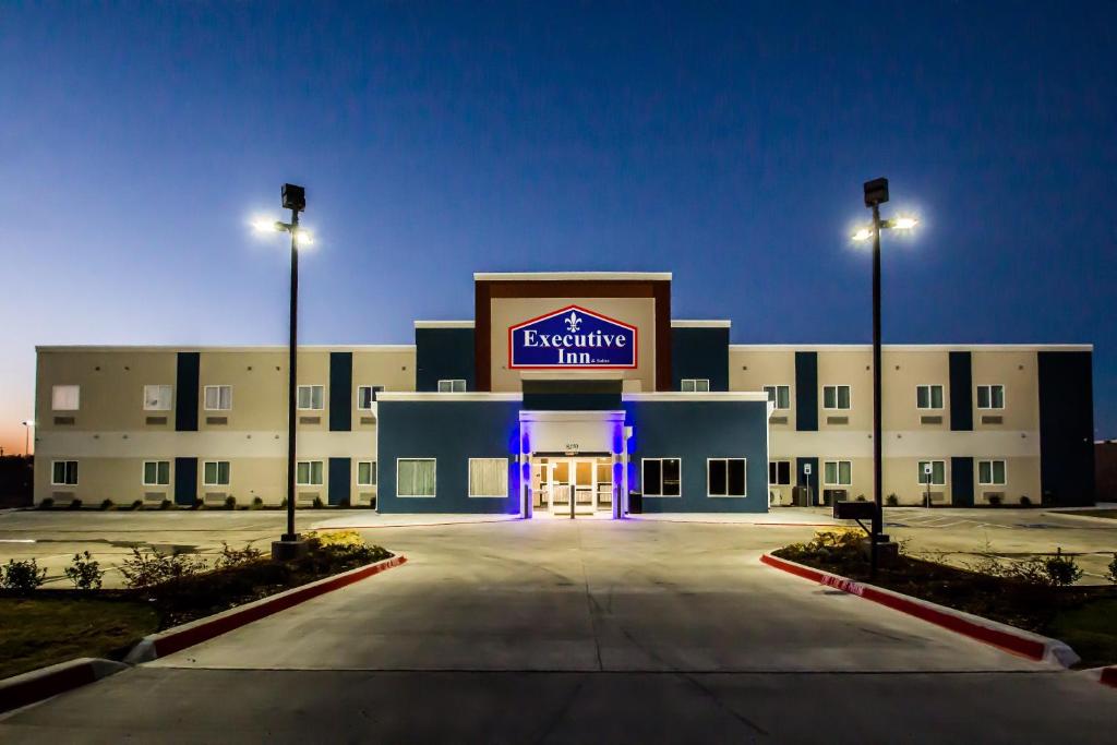 a large building with a lit up sign on it at Executive Inn Fort Worth West in Fort Worth