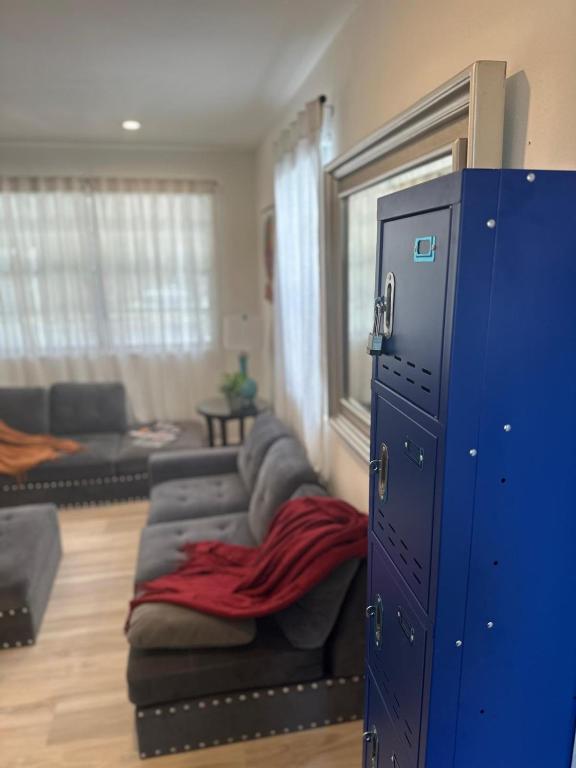 a living room with a couch and a blue cabinet at Daphne's Tropical Oasis Boutique Hostel in Hallandale Beach