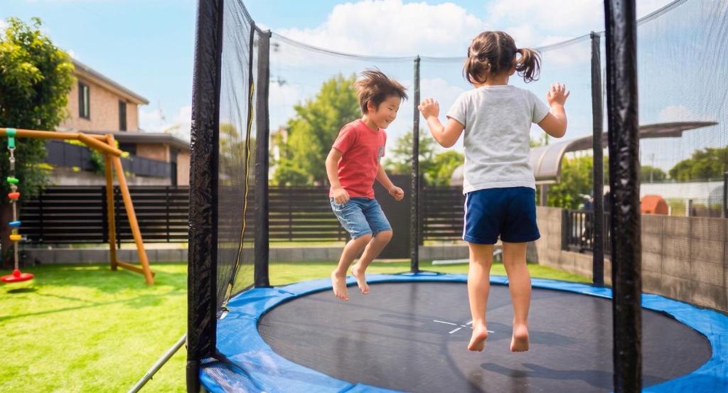 two little girls jumping on a trampoline at Asobico焼津 in Yaizu