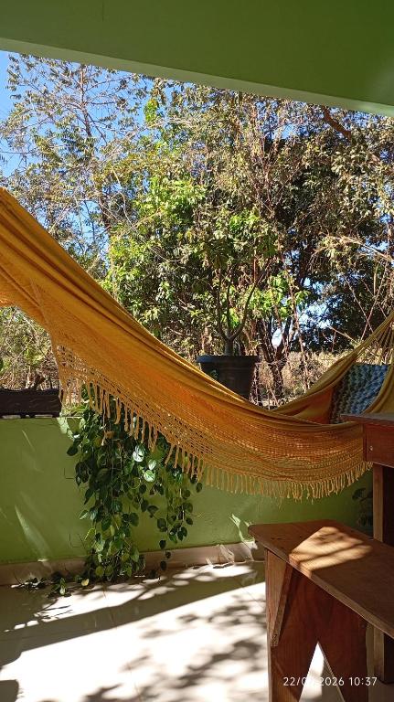 a hammock on a porch with trees in the background at Casa Baunilha in Cavalcante