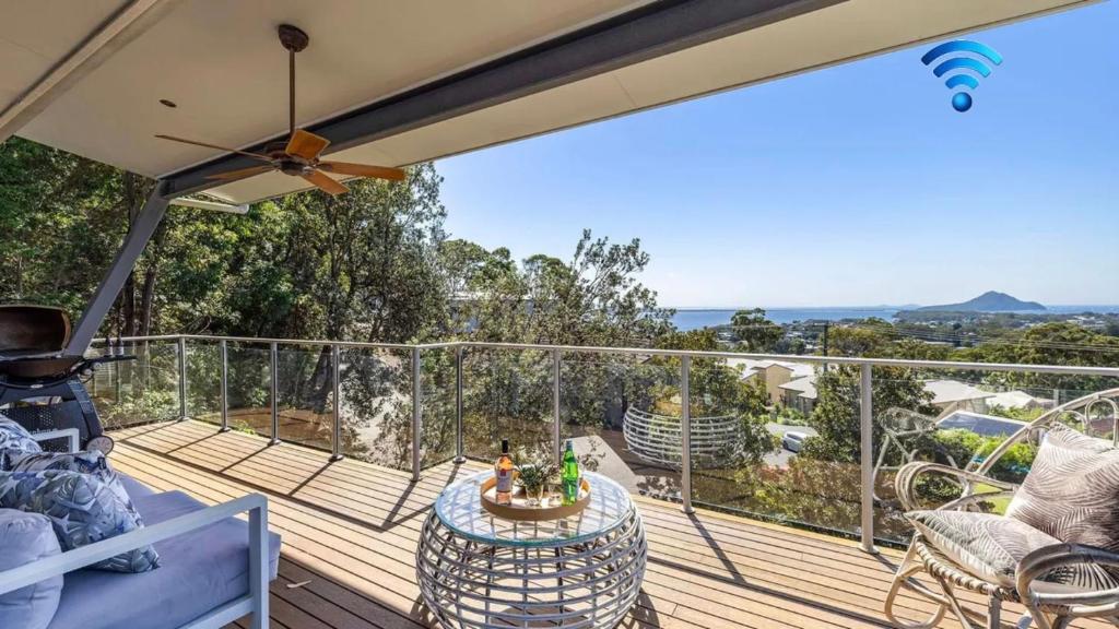 a balcony with a table and chairs on a deck at Hamptons By The Bay in Nelson Bay