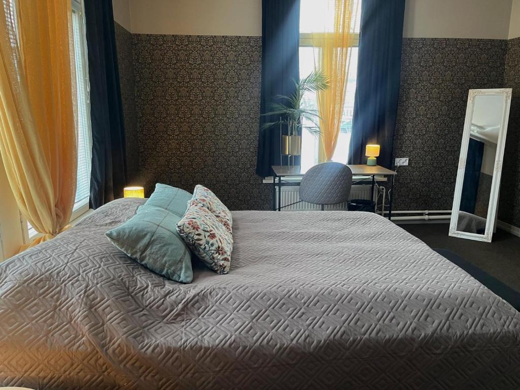 a bedroom with a bed with pillows on it at Johanssonin talo 1849 in Joensuu