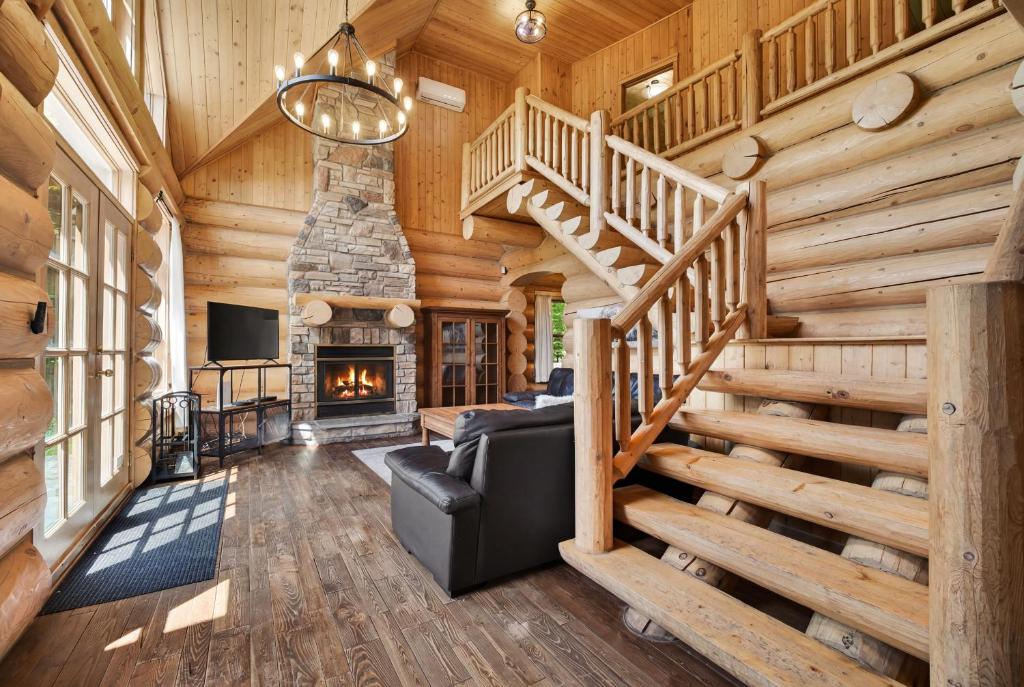 a living room with a staircase and a fireplace at Fiddler Lake Resort - Bear 25 in Mille-Isles