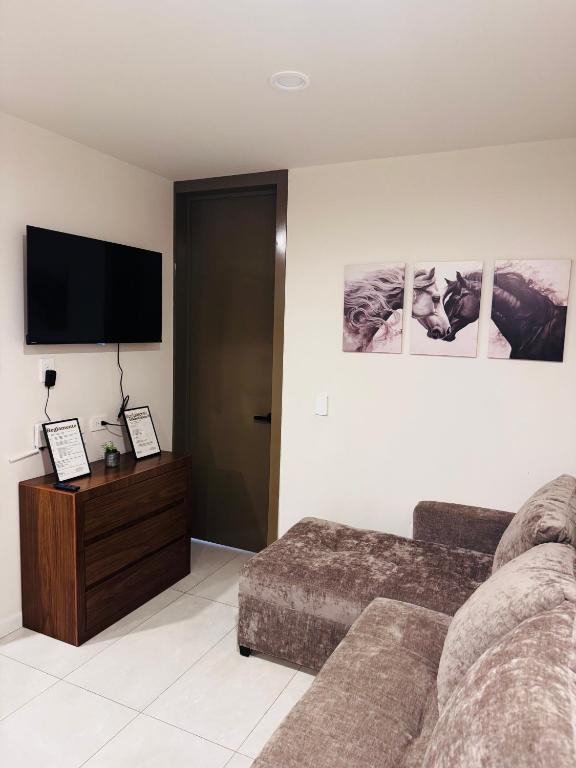 a living room with a couch and a flat screen tv at Refugio urbano Saori in Guadalajara