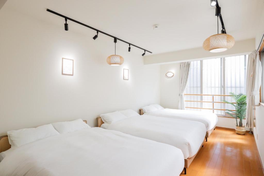 two white beds in a room with a window at 栞-shiori-NAKASONE in Miyako-jima