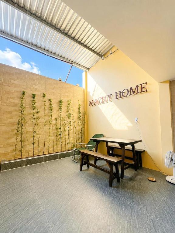 a room with a picnic table and aiety home sign at Machy Home in Phú Quốc