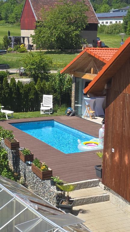 a swimming pool sitting next to a house at Karolingerweg Gäst Haus in Lauterhofen