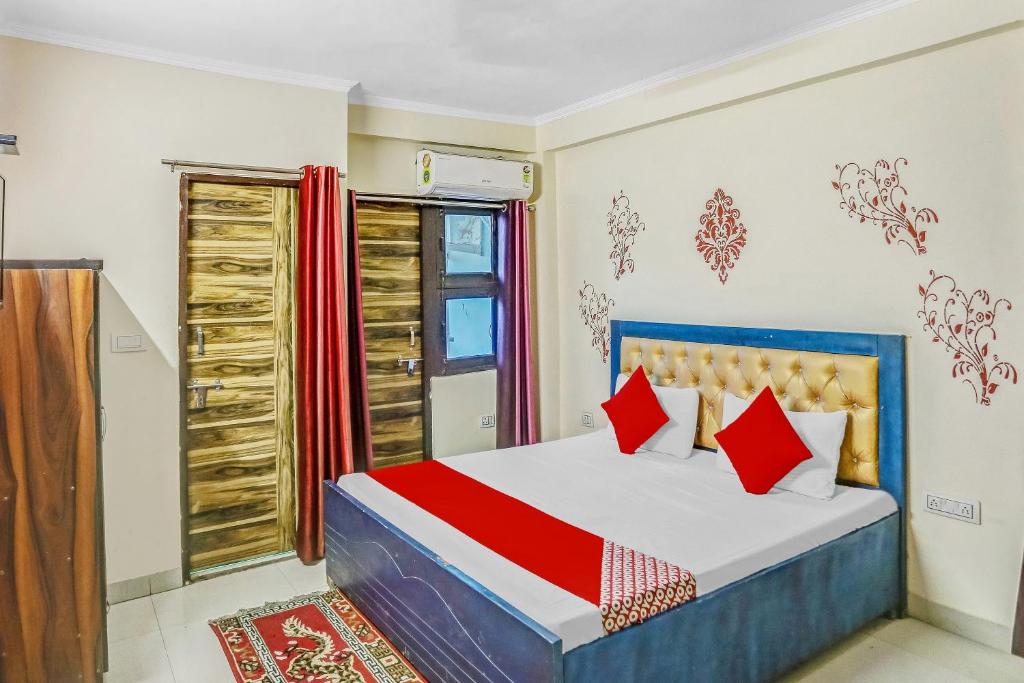 a bedroom with a bed with red pillows at Super Hotel O Shankar Hotel Ghaziabad Railway Station in Ghaziabad