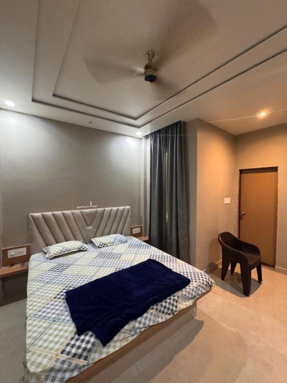 a bedroom with a bed and a chair in it at Sunita Kunj in Jhūsi
