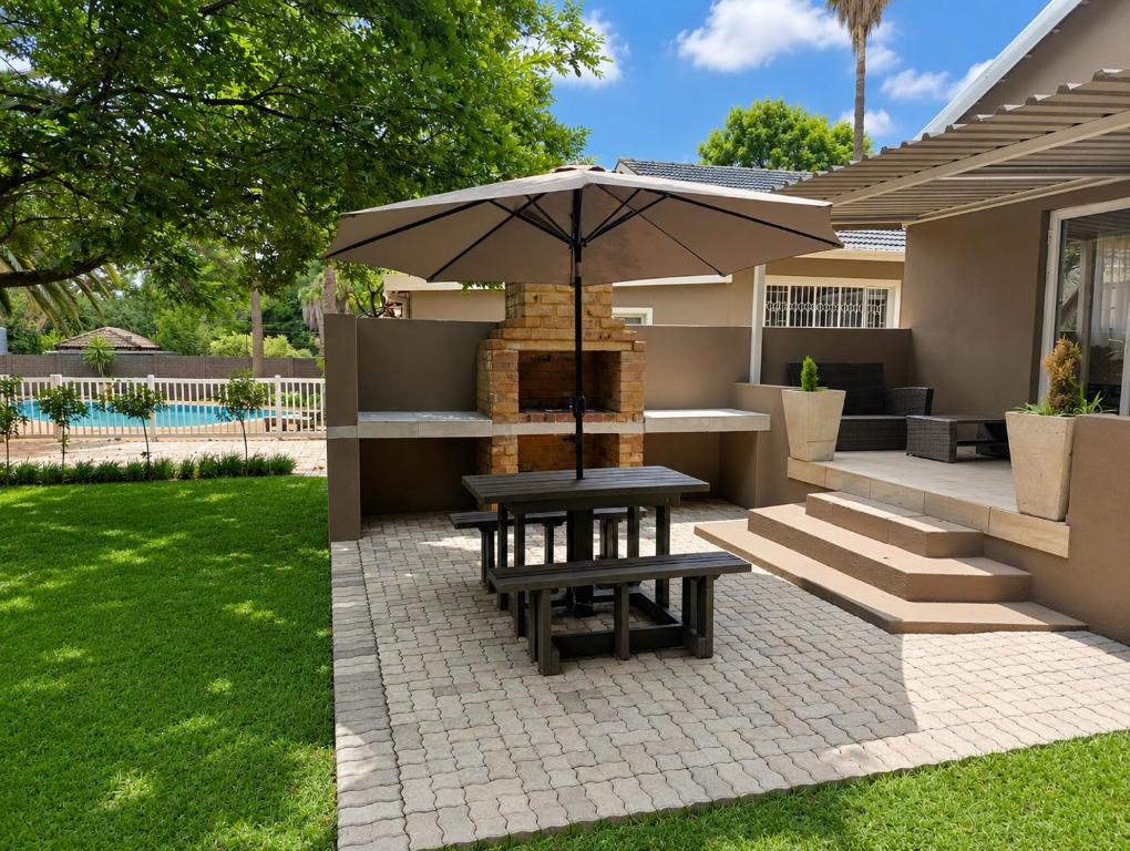 a patio with a picnic table and an umbrella at Joy Haven - Cottage in Centurion