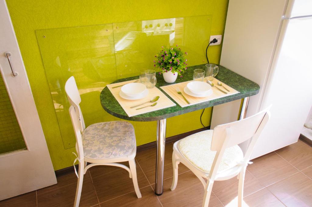 uma pequena mesa com duas cadeiras e uma parede verde em Poltava Green Apartments em Poltava