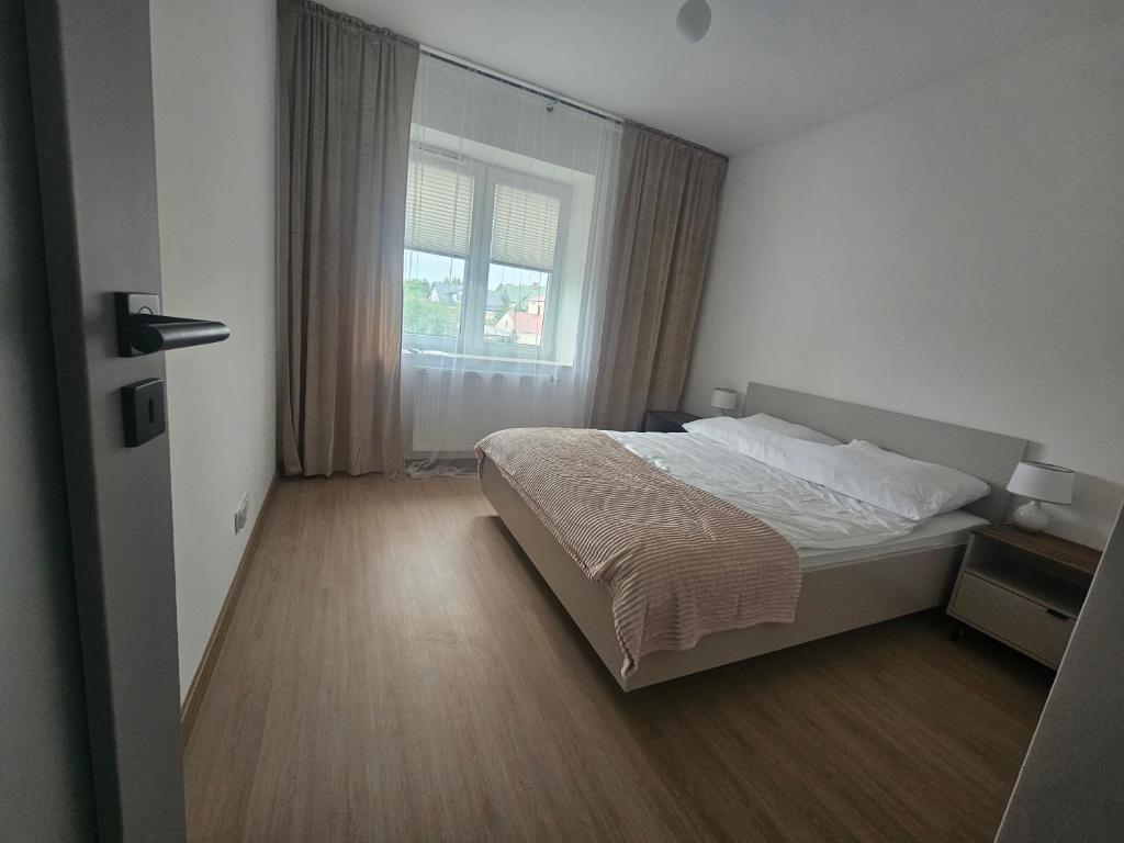a bedroom with a large bed and a window at Apartament Centrum in Giby