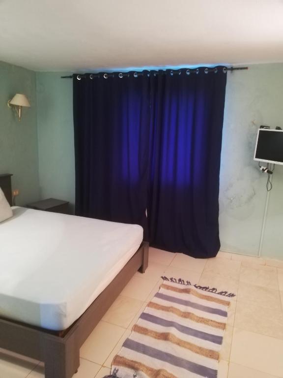 a bedroom with a bed and a blue curtain at Dari in El Haouaria