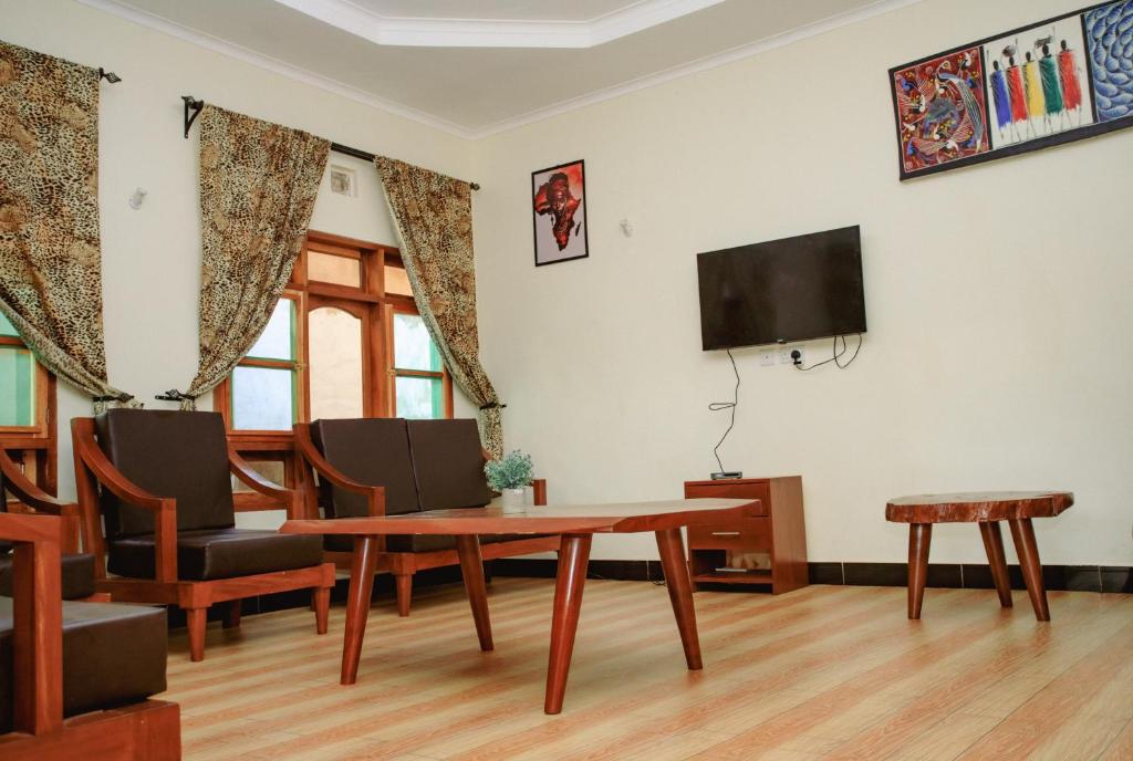 a living room with a table and a tv at Panofu Homestay in Moshi