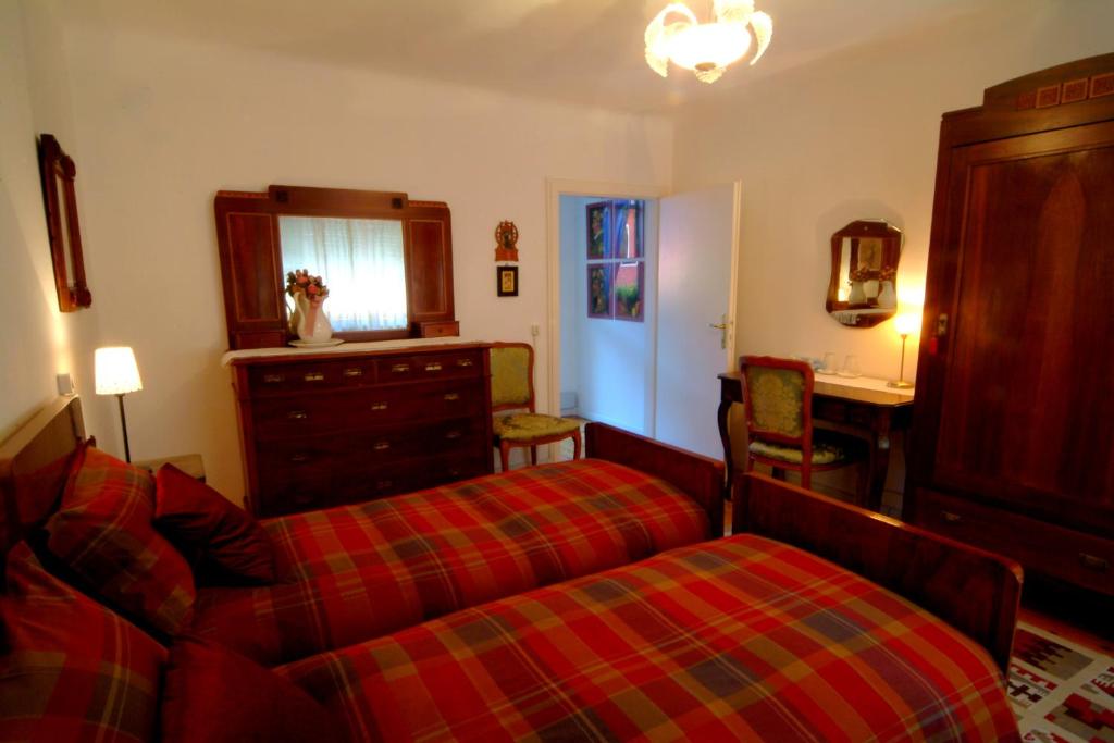 a bedroom with two beds and a dresser and a mirror at B&B gil d'o in Bertiolo