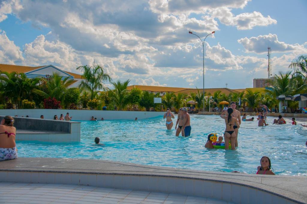 a group of people in the swimming pool at a resort at Lacqua di Roma, com fogão geladeira e parque aquático 24h in Caldas Novas