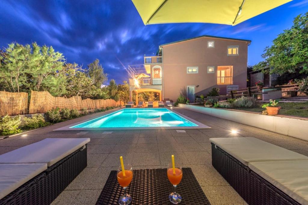 a swimming pool in a backyard with a house at My Dalmatia - Apartment Nostromo in Pag