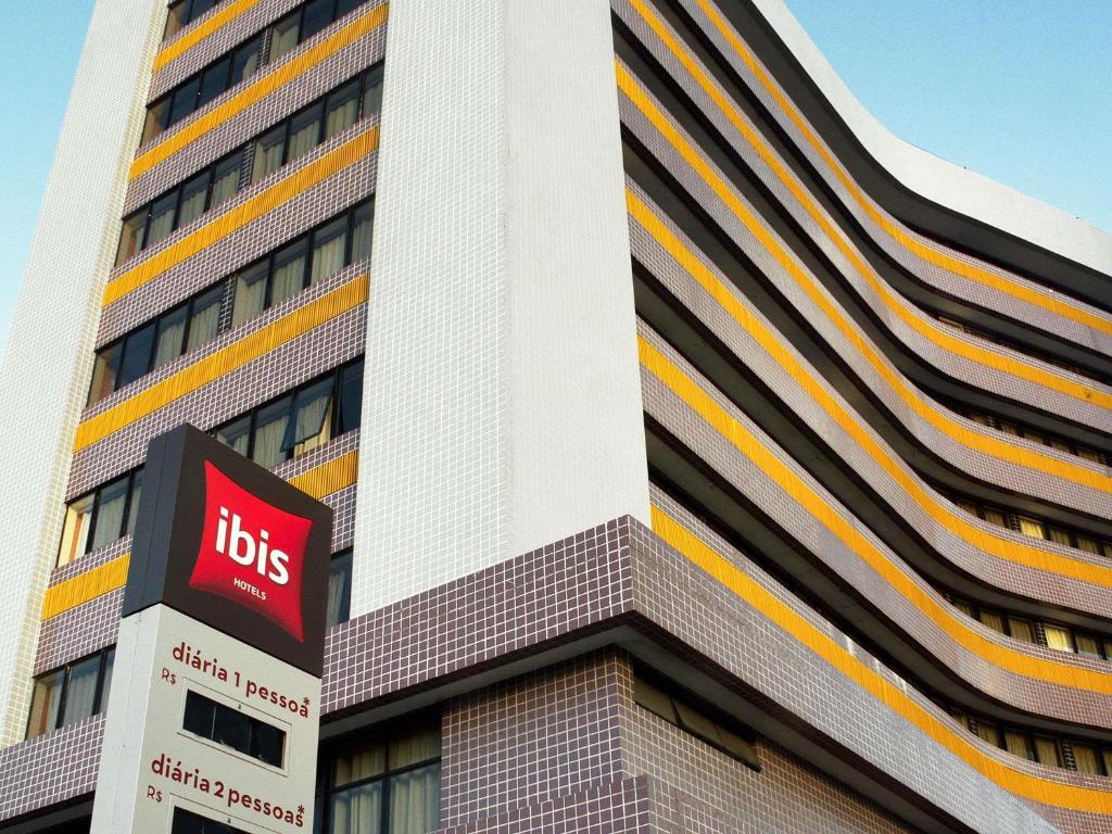 a tall building with a bus sign in front of it at ibis Maceio Pajuçara in Maceió