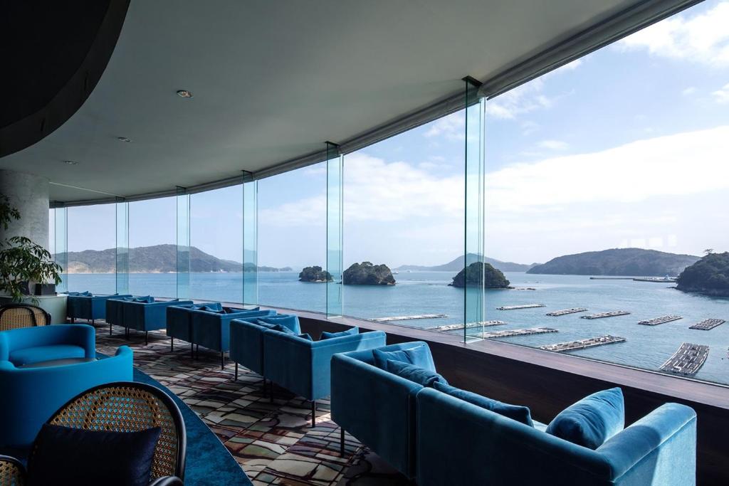 a view of the water from a room with blue chairs at Toba Grand Hotel in Toba