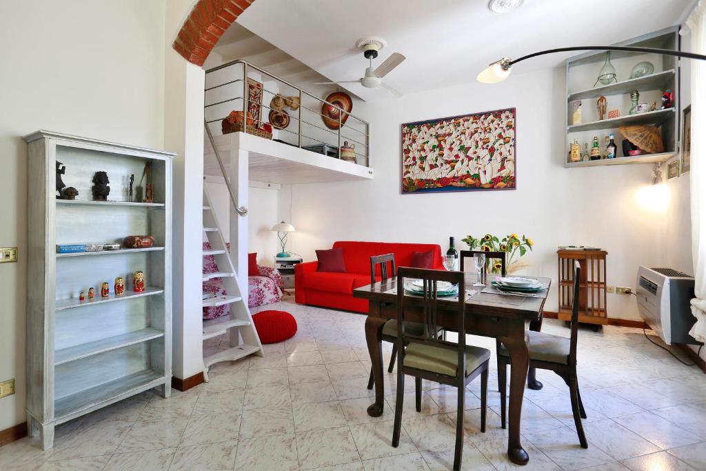 a living room with a table and a red couch at Oltrarno Home Silvia Florence in Florence