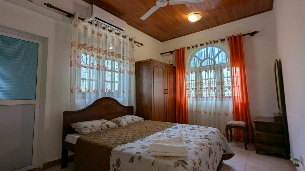 a bedroom with a bed and two windows at Margarita Leisure in Wadduwa