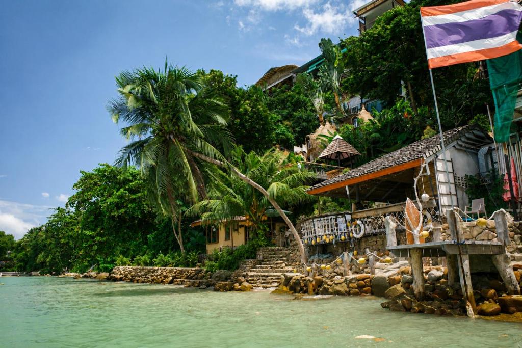 a flag flying in the water next to a house at Salty Pearl Beach Front Phuket in Patong Beach