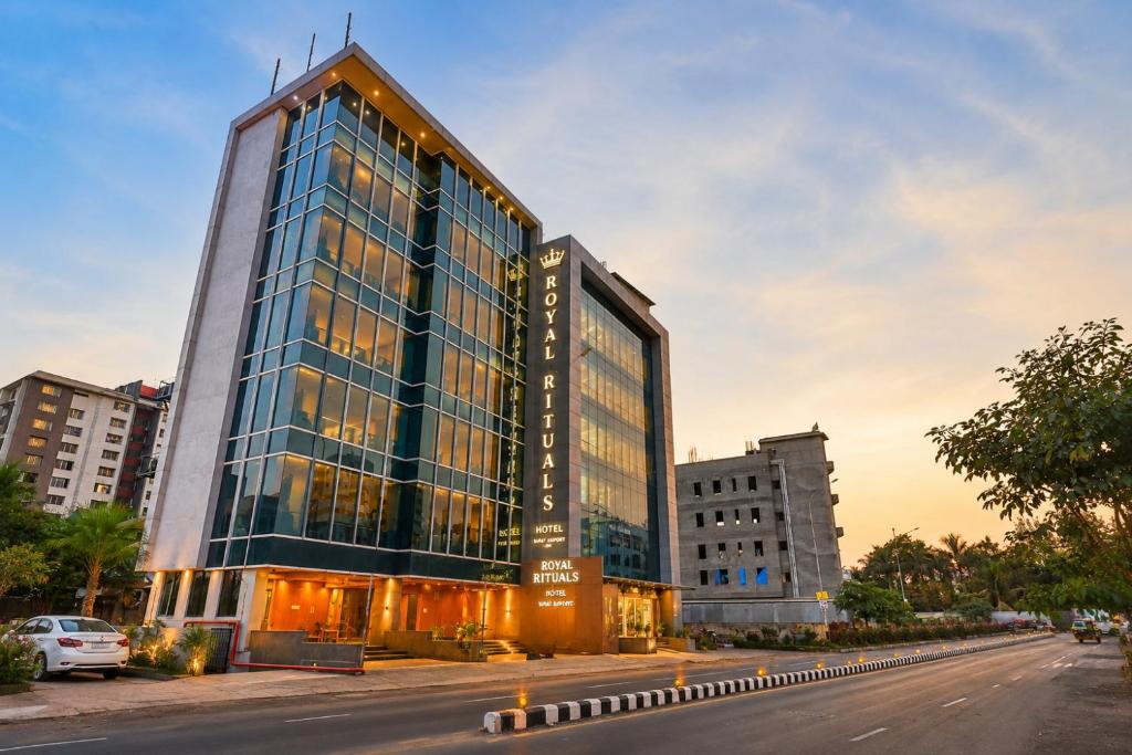a tall glass building on the side of a street at Hotel Royal Rituals in Surat