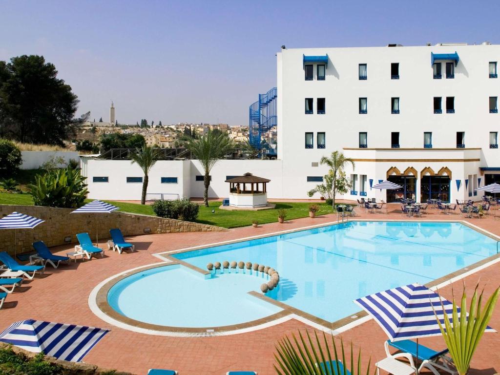 a large swimming pool in front of a hotel at Ibis Meknès in Meknès