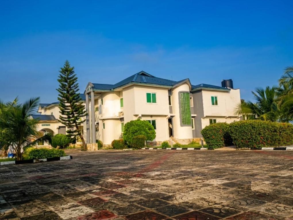 a large white house with green shutters at Floyds Beach Resort & Spa in Nyanyanu