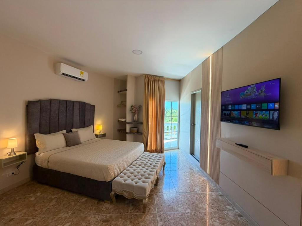 a bedroom with a bed and a tv on the wall at HOTEl LA CANDELARIA ROOM HOUSE in Mangue