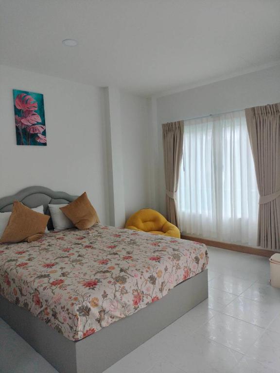 a bedroom with a bed with a floral comforter at Aysaii Home02 in Panwa Beach
