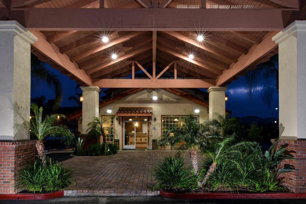 une maison dotée d'un plafond en bois et d'une terrasse couverte avec des plantes dans l'établissement Best Western Capistrano Inn, à San Juan Capistrano