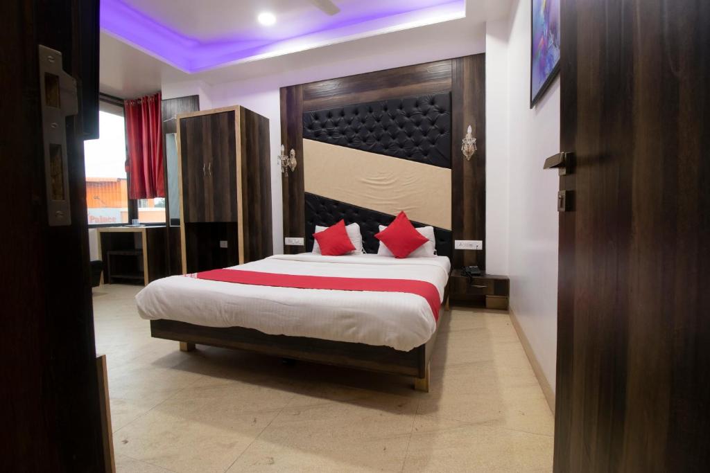 a bedroom with a large bed with red pillows at Hotel O Sai Plaza in Aurangabad