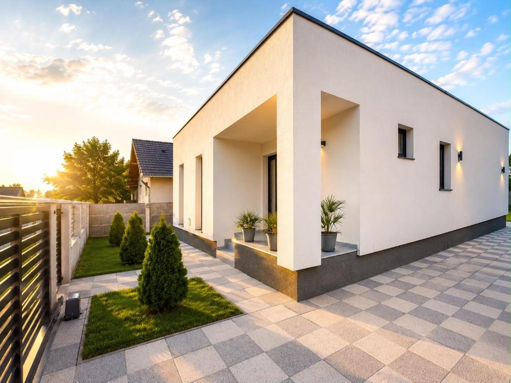 a white house with a courtyard with potted plants at Casa Mediteraneana Verde in Alba Iulia