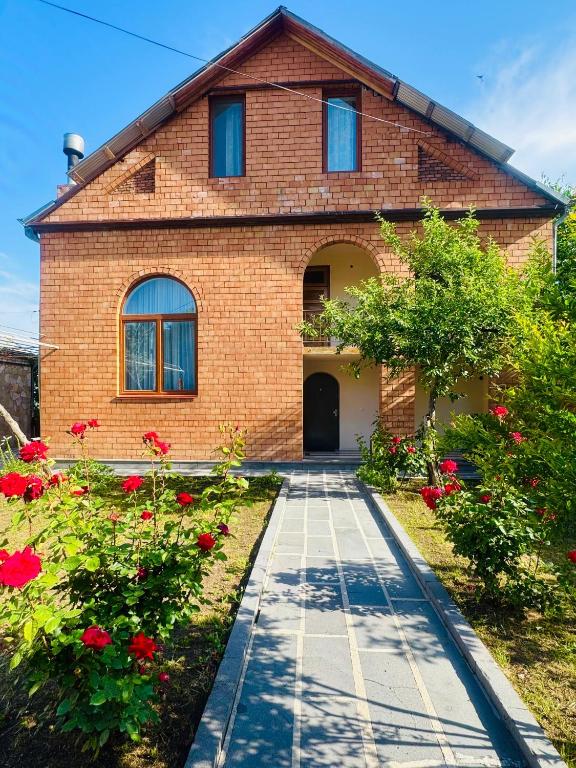 a brick house with red flowers in front of it at Bolnisi Elia in Bolnisi