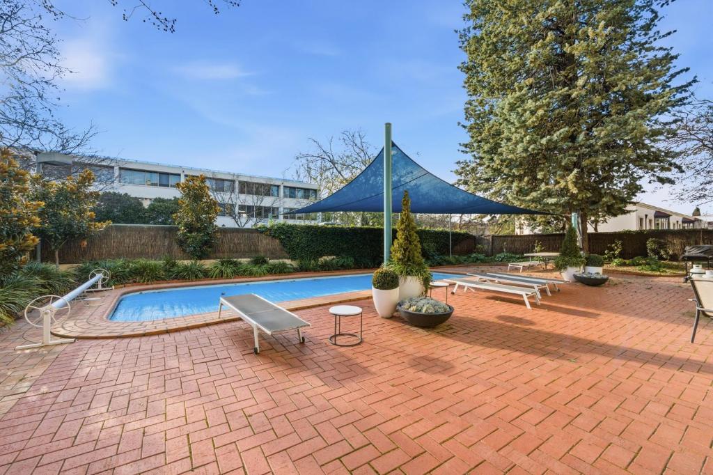 a swimming pool with a blue tent in a yard at Stylish 2-Bed Apartment in Kingston in Kingston 