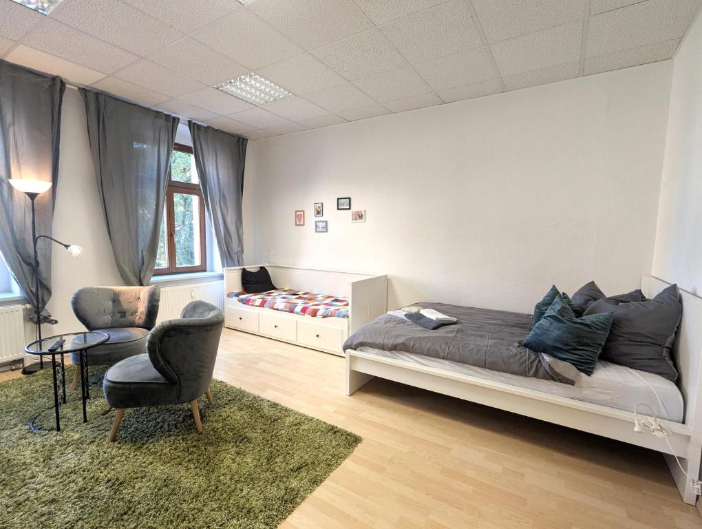 a bedroom with a bed and a chair and a table at Grosses Zimmer im Zentrum Elise , ruhig & gemuetlich in Chemnitz